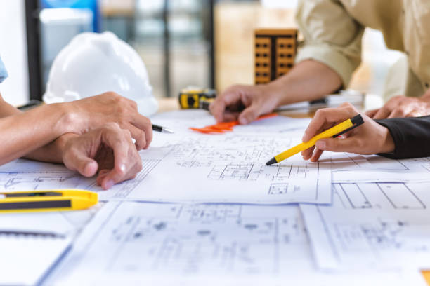 istockphoto-929029342-612×612 Image of team engineer checks construction blueprints on new project with engineering tools at desk in office.